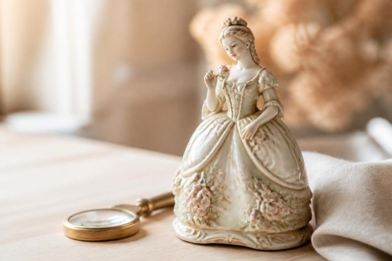 Figurita de porcelana antigua junto a una lupa para revisar su autenticidad